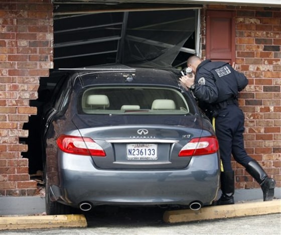 A Jefferson Parish Sheriff's deputy looks at the damage to the inside of the building as JPSO deputies and firefighters investigated an accident in which a car plowed through the front of Stepping Stone Montessori School in Terrytown, La., on Wednesday.
